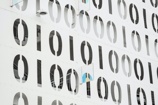 Facade of modern building; a random sequence of 1's and 0's are written on the facade's surface.