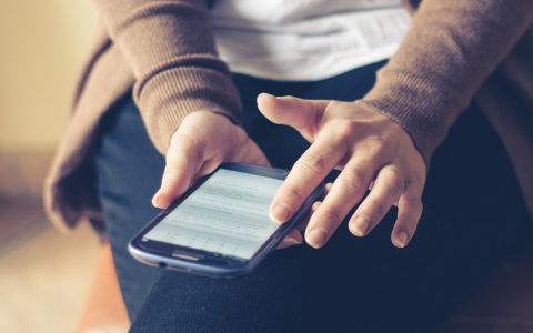 A close-up image of a person's using a smartphone.